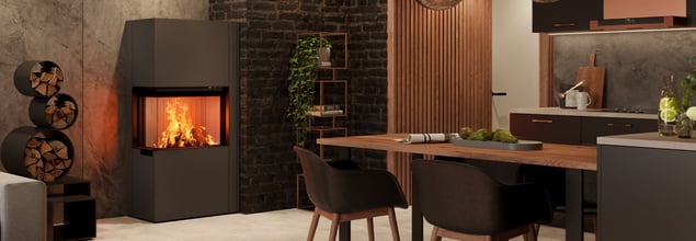 Ein dunkelgrauer Kamin in einem Wohn-Essbereich, der mit dunklen Farben und Holz eingerichtet ist.