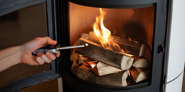 Person entfacht Feuer im Kamin