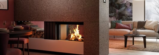 Doppelseitiger Kamineinsatz dient als Raumteiler zwischen Wohn- und Essbereich.