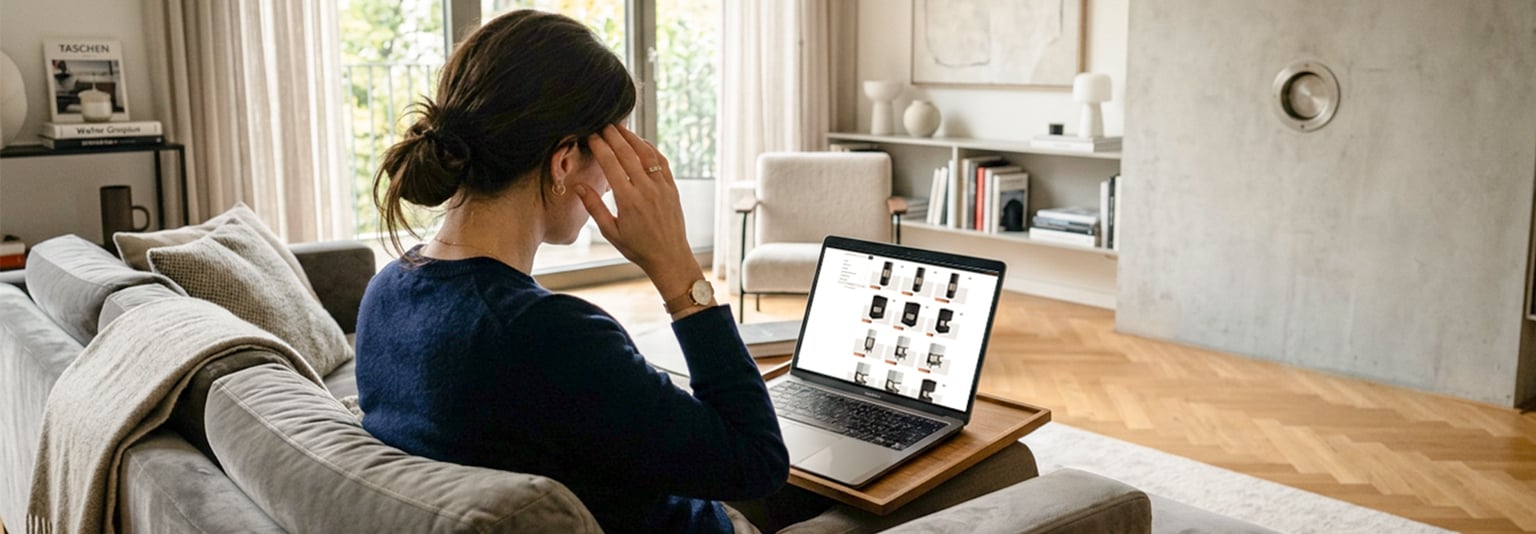 Frau sitzt überfordert mit der Auswahl an Kaminen vor ihrem Laptop