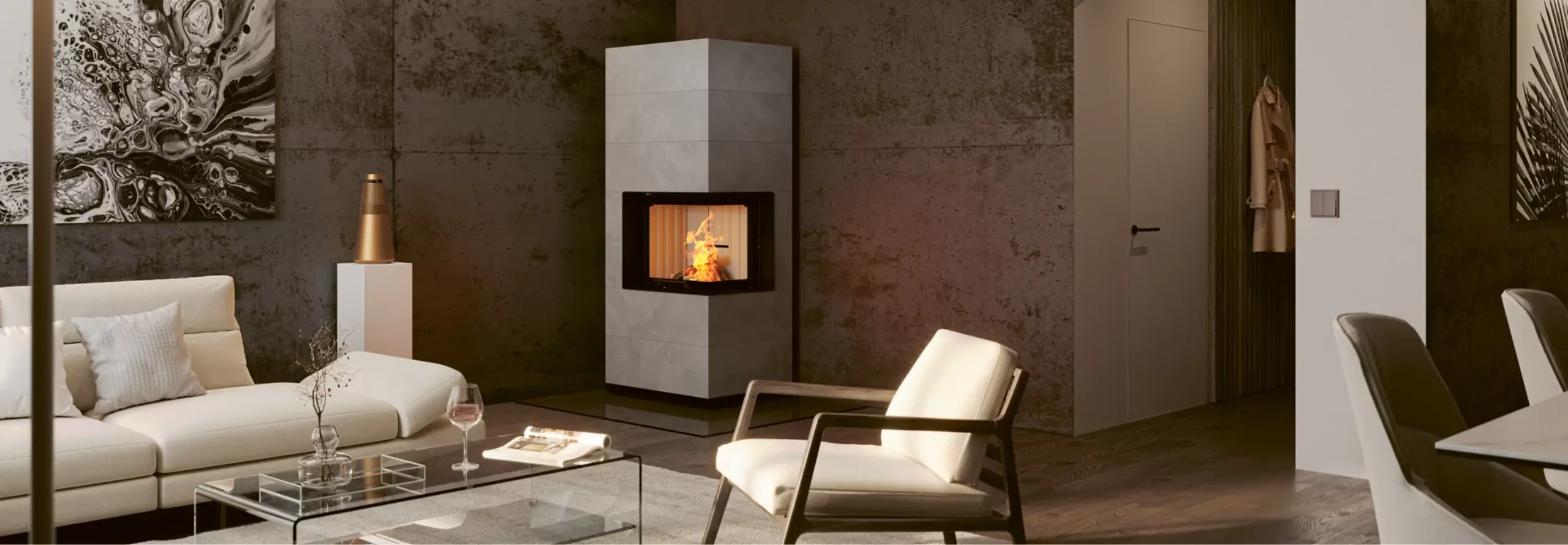 Ein grauer Kaminofen steht in der Ecke eines modern und edel eingerichteten Wohnzimmers neben einer cremefarbenen Couch.