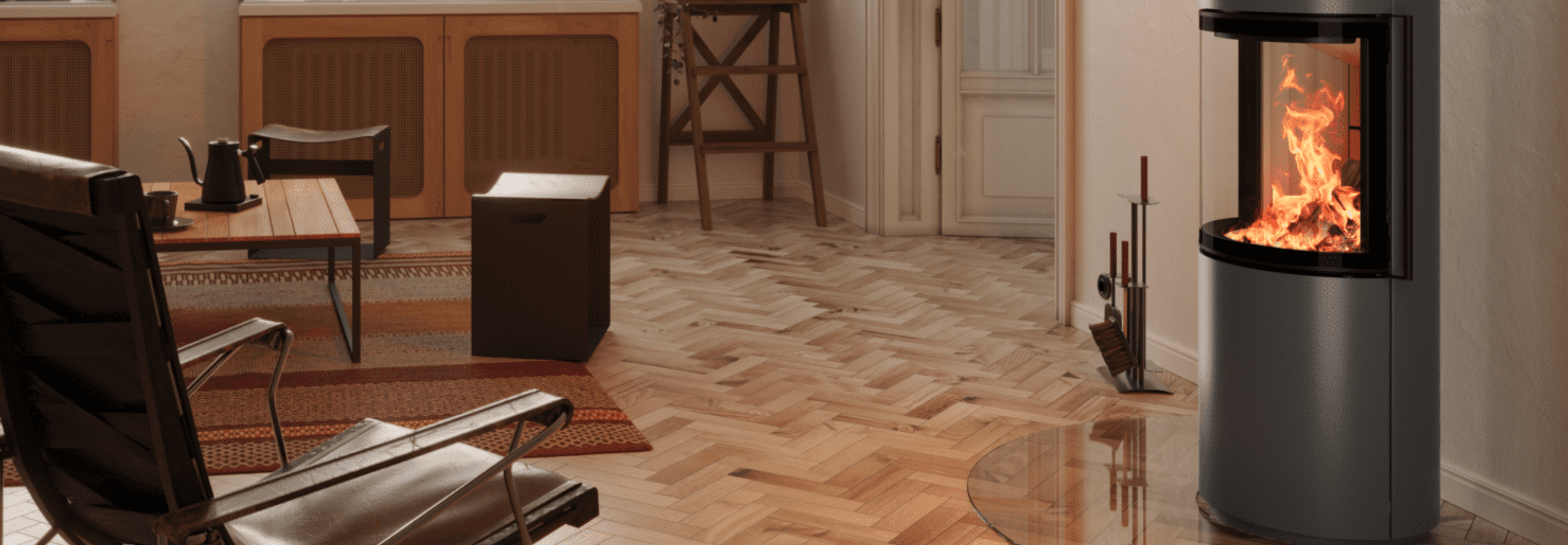 Ein anthrazitfarbener Kaminofen mit brennendem Feuer steht in einem Wohnzimmer vor einer weißen Wand mit einem Sessel gegenüber.